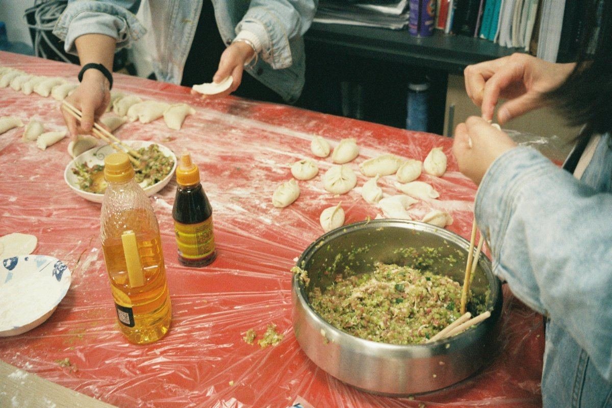 一家人围着餐桌一起包饺子的手