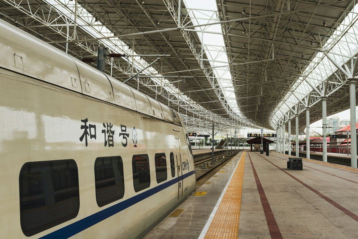 一列白色高速列车停靠在站台旁