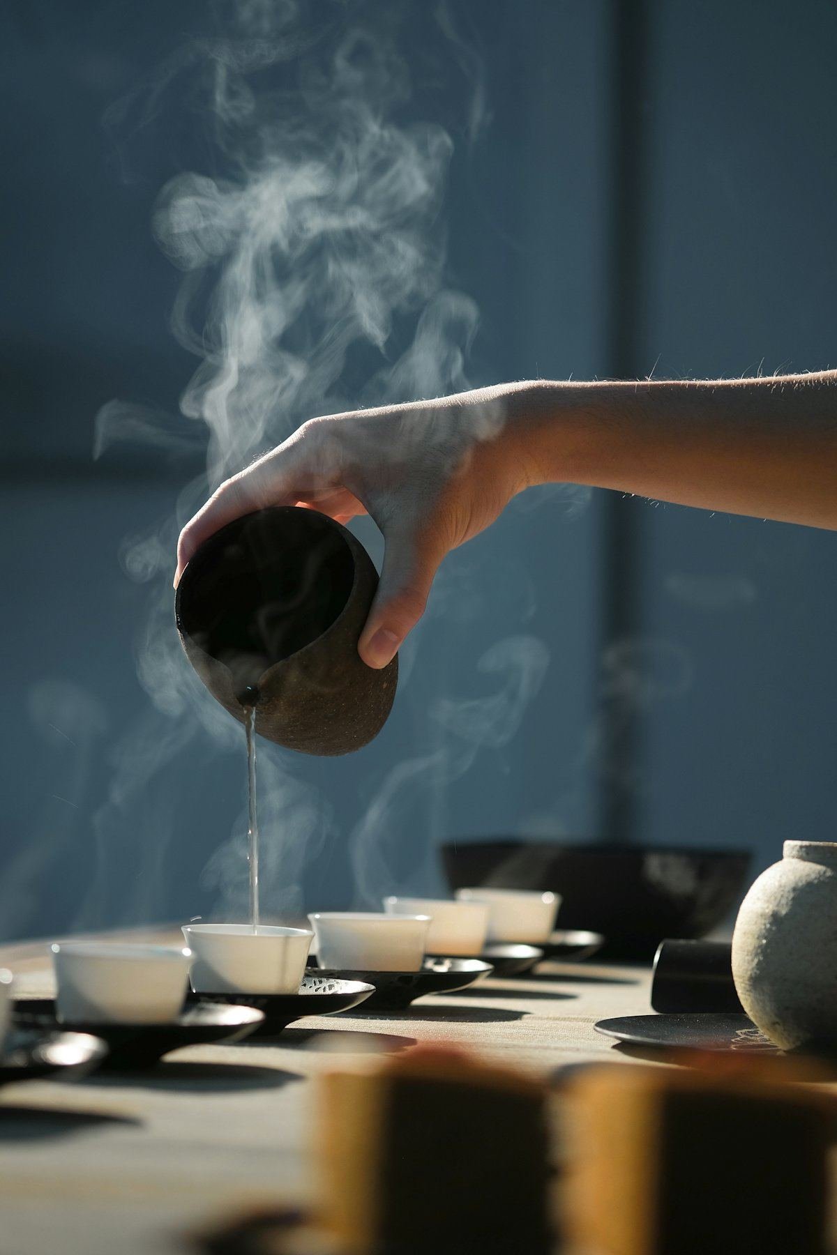 热茶从小壶中依次斟入一排茶杯