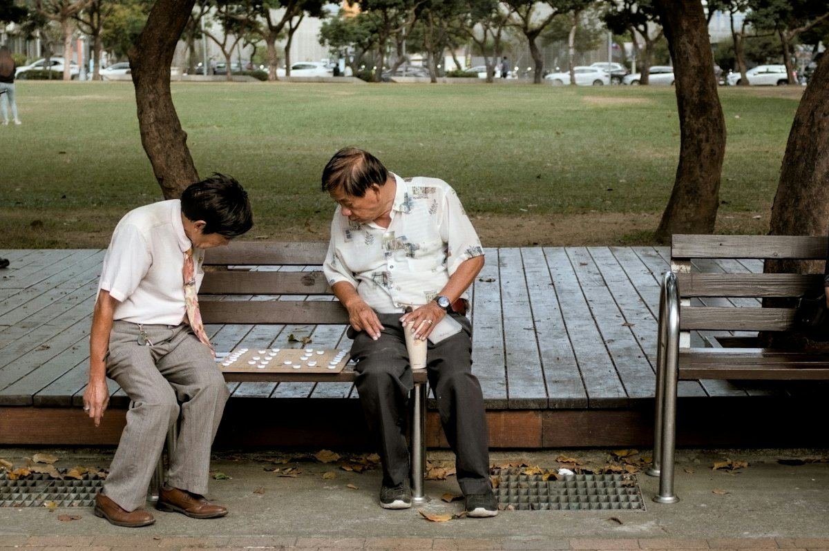 两位老人在公园长椅上下棋
